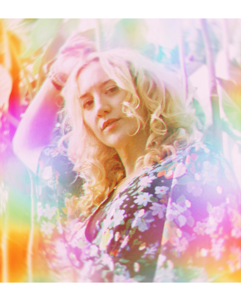 Hannah Telle in a floral print top, set against a heavily stylized, colorful, and hazy background.