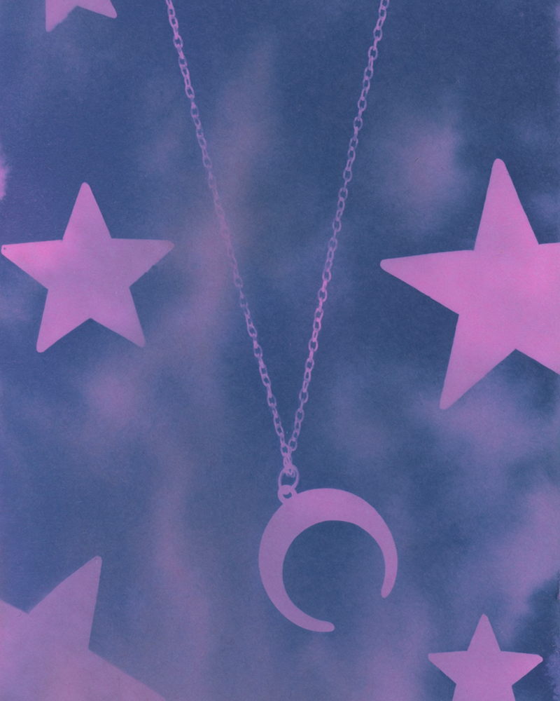 Cyanotype of a necklace with a crescent moon pendant surrounded by stars